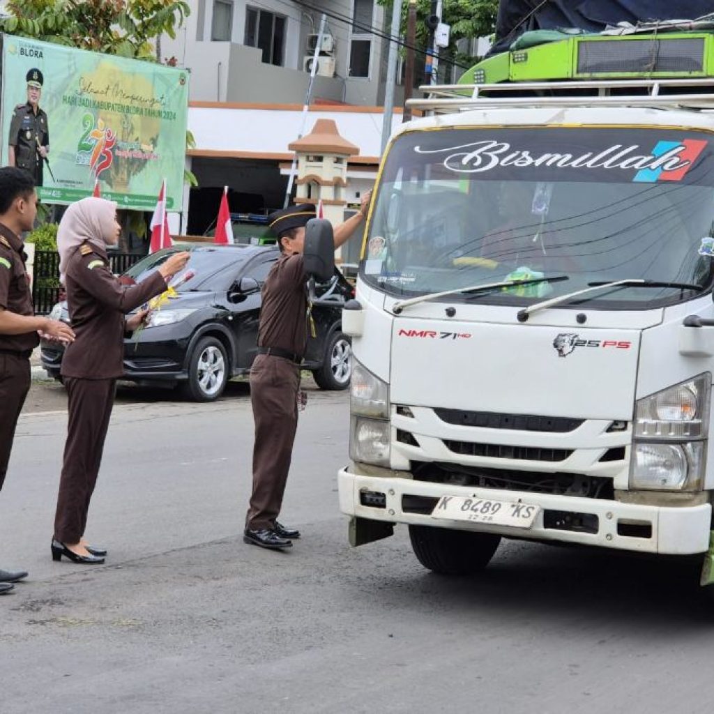 Kejari Blora membagikan stiker dan bunga kepada warga saat memperingati Hakordia 2024. Foto: Istimewa