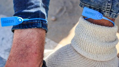 Para pekerja Palestina di Israel dipasangi gelang yang bertuliskan nomor selama ditahan di Israel. Foto: X.com/michael_galant