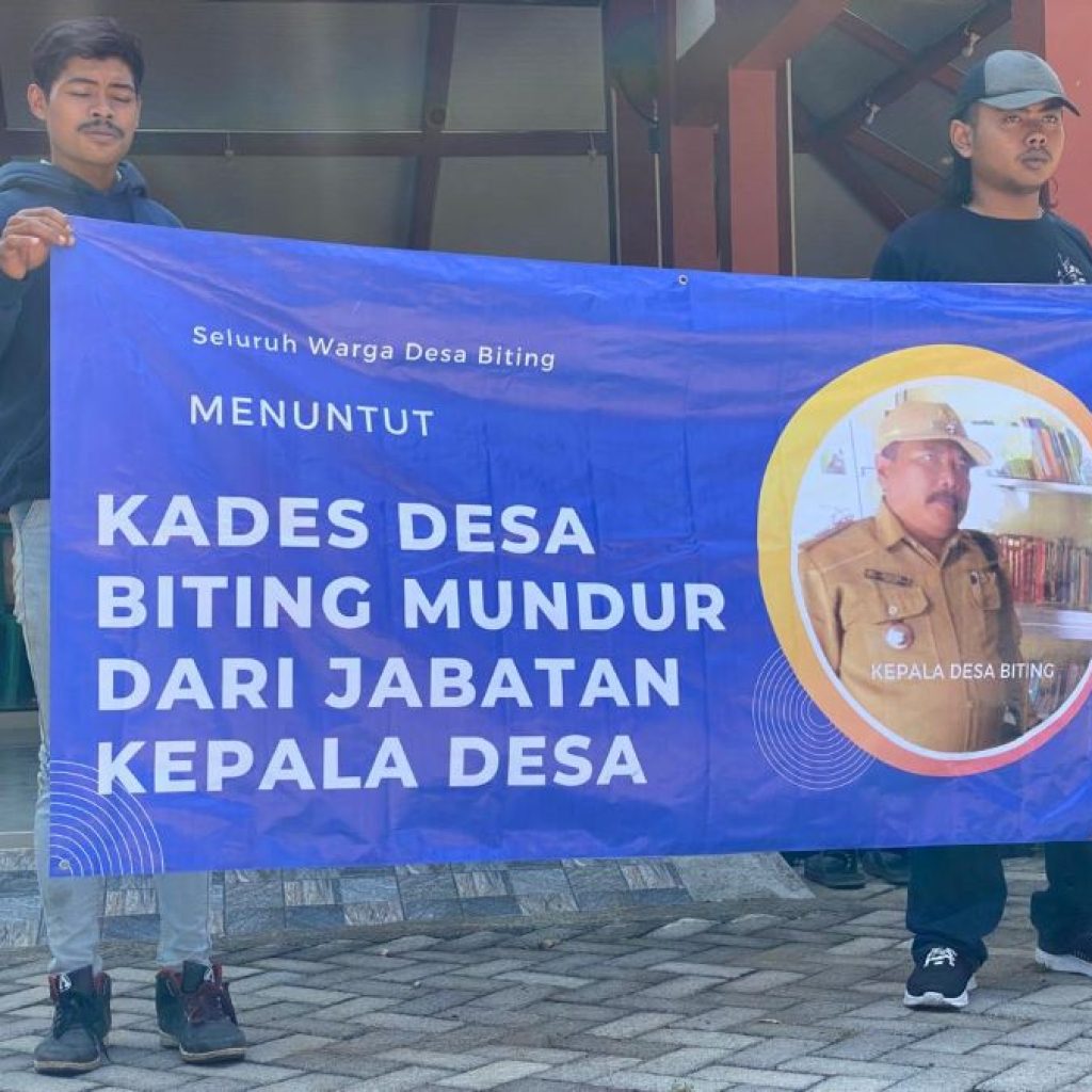 Masyarakat Desa Biting bawa banner untuk menuntut Kades Biting mundur. Foto: Istimewa