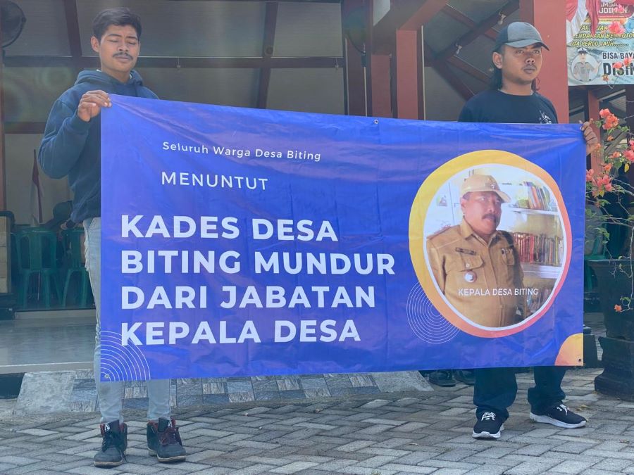 Masyarakat Desa Biting bawa banner untuk menuntut Kades Biting mundur. Foto: Istimewa