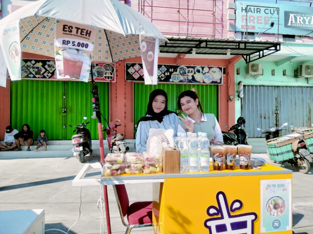 Dua gadis yang berjualan saat momen pawai pembangunan di Blora. Foto: Istimewa